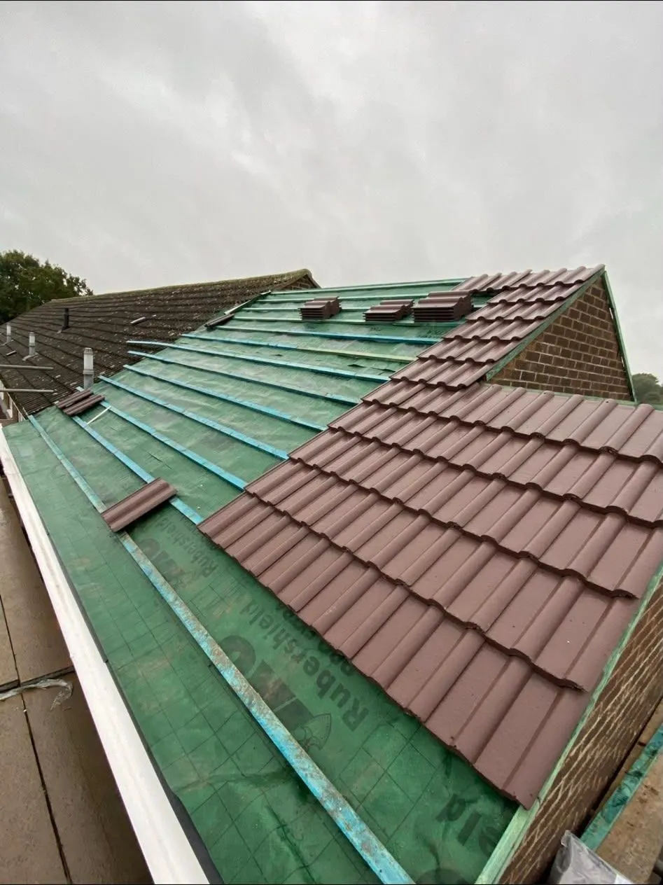 New tiles being laid over fresh membrane on a re-roof