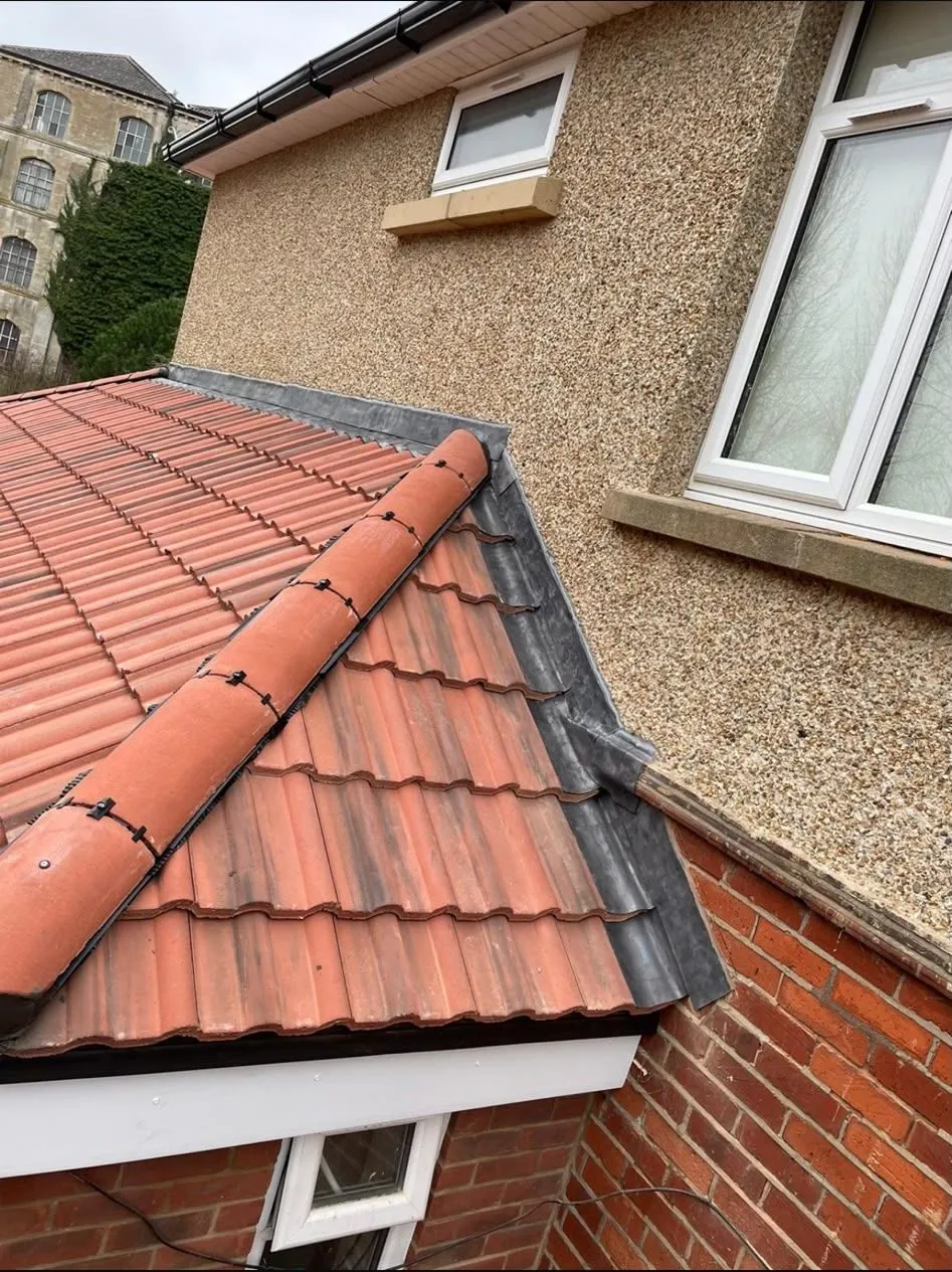 Fresh ridge tiles and lead flashing after a roof repair